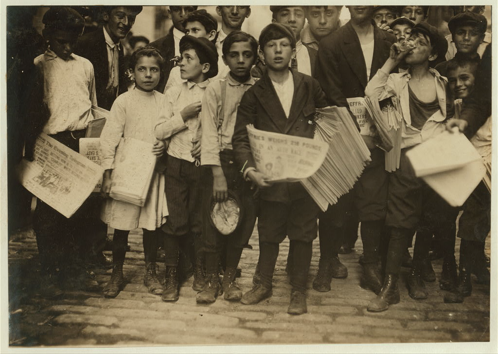 Newsboys and a newsgirl getting afternoon papers on Park Row, New York, July 1910